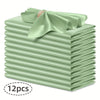 A stack of twelve light green silky satin dinner napkins with a decorative bow on top.