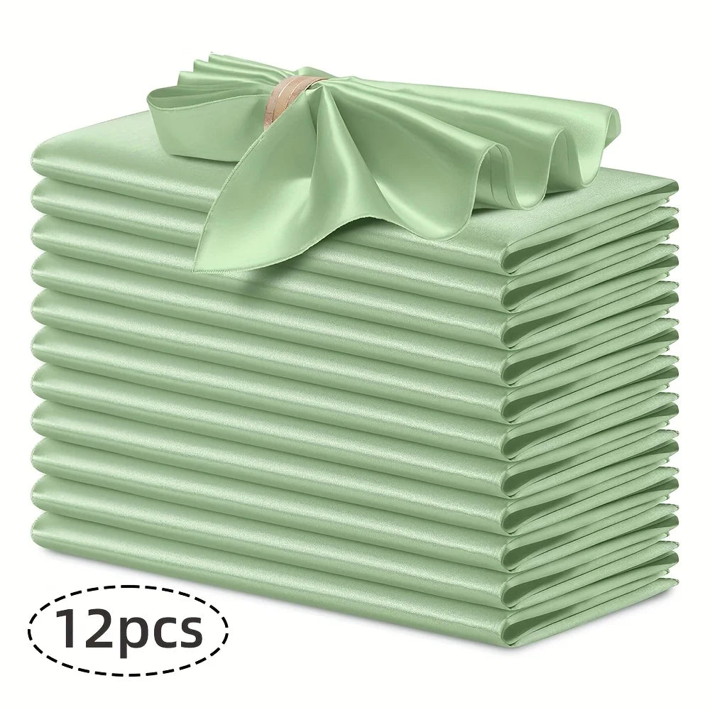A stack of twelve light green silky satin dinner napkins with a decorative bow on top.