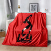 A red flannel throw blanket featuring a black silhouette of a dancer and the text THE MUSICAL