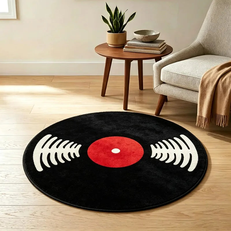 A round black rug with a red center and white sound wave graphics, placed on a light wooden floor.