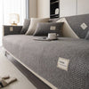A gray linen sofa cover cushion with a textured weave rests on a light-colored floor.