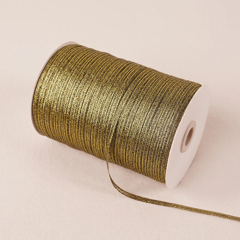 A roll of 10-meter gold and silver glitter satin ribbon with a white core.