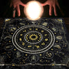 Hands holding a glowing orb above a dark cloth featuring an astrological chart and zodiac symbols.