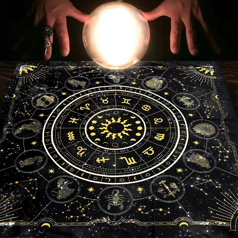 Hands holding a glowing orb above a dark cloth featuring an astrological chart and zodiac symbols.