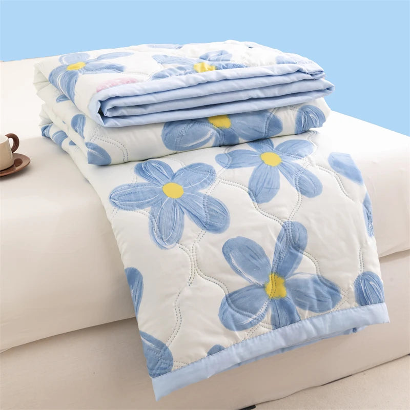 Light blue floral duvet cover folded on a white surface with yellow accents