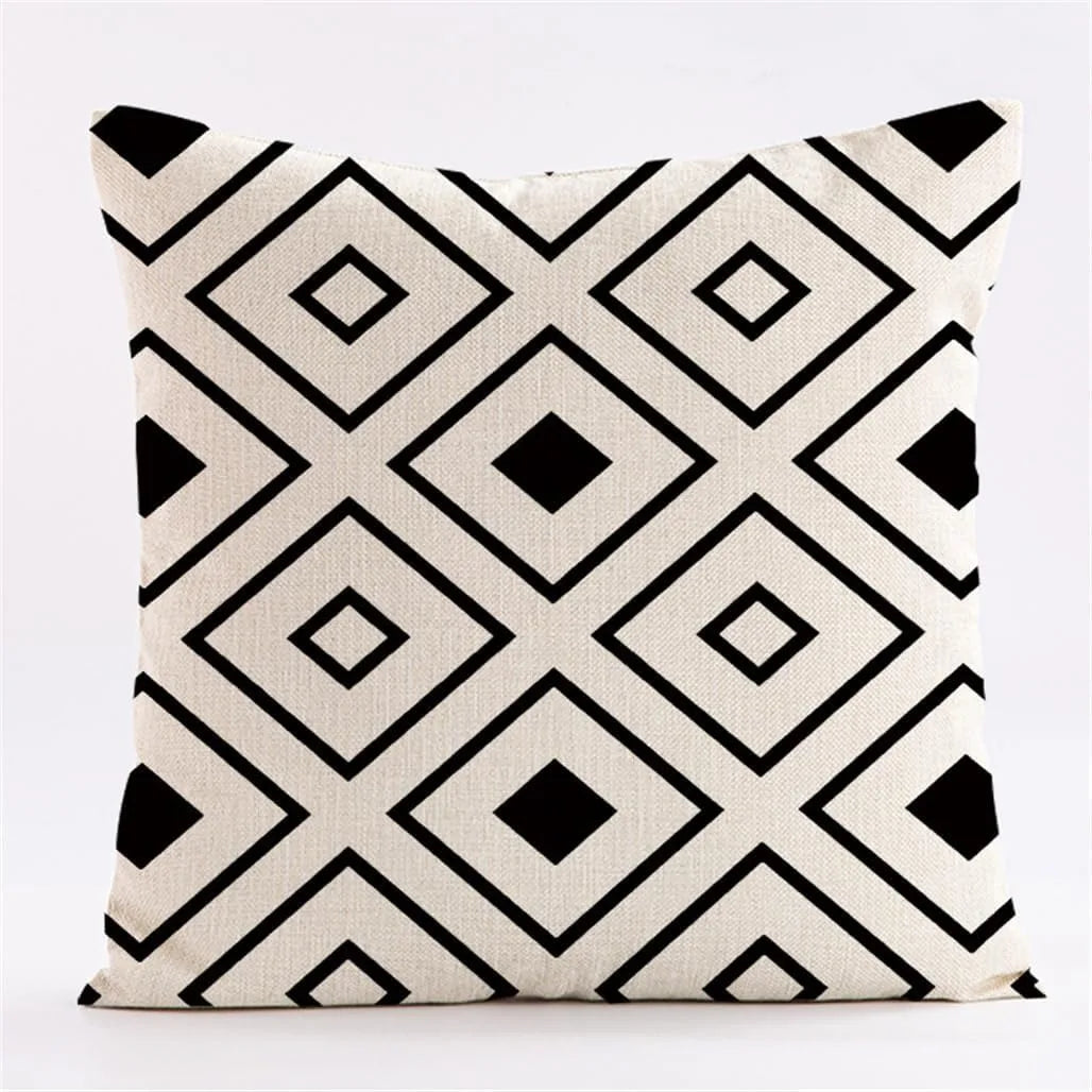 A geometric black and white patterned throw pillow cover