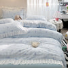 A bed with a floral bowknot duvet cover set featuring blue and white gingham patterns.