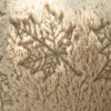 Close-up of fuzzy beige throw pillow covers featuring a detailed maple leaf embroidery pattern.