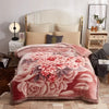 A pink floral weighted blanket displayed on a bed with white and beige bedding.