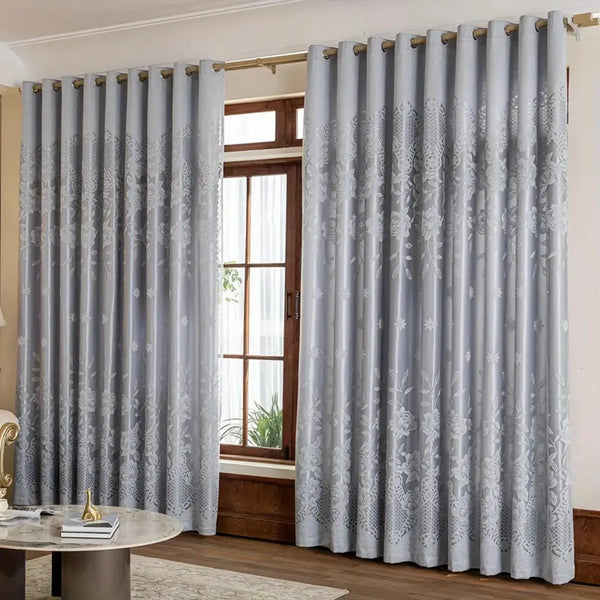 Light gray vintage floral blackout curtain panels hanging in a window frame.