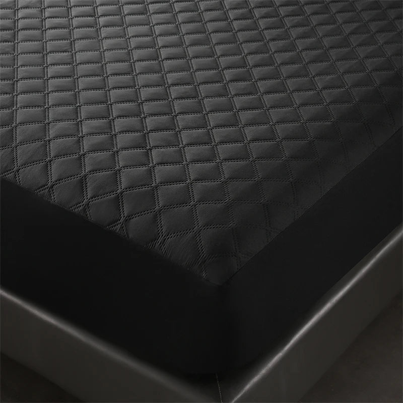 Close-up view of a black waterproof quilted mattress protector fabric texture.