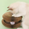 A white cat is interacting with a brown, corrugated folding cat scratching board set.