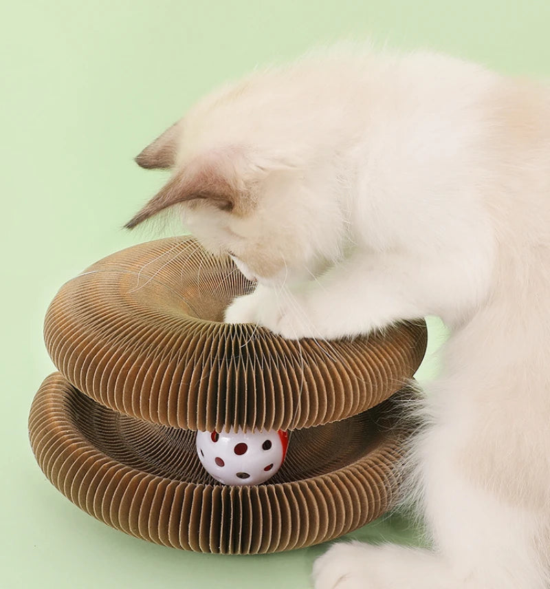 A white cat is interacting with a brown, corrugated folding cat scratching board set.