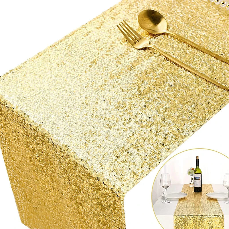 Golden sequin table runner with gold cutlery set on a table.