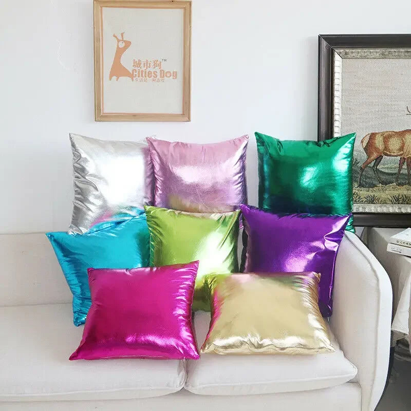 A collection of vibrant metallic solid color pillow covers in shades of silver, pink, green, purple, and gold arranged on a w
