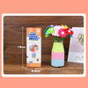 A DIY felt flower craft kit showing a bouquet of colorful fabric flowers in a glass vase.