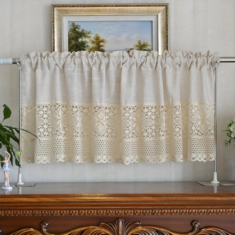 A cream-colored linen crochet half curtain with delicate eyelet detailing hanging over a wooden surface.