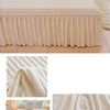 A plush linen bed skirt set in cream color with a ribbed texture shown on a bed.