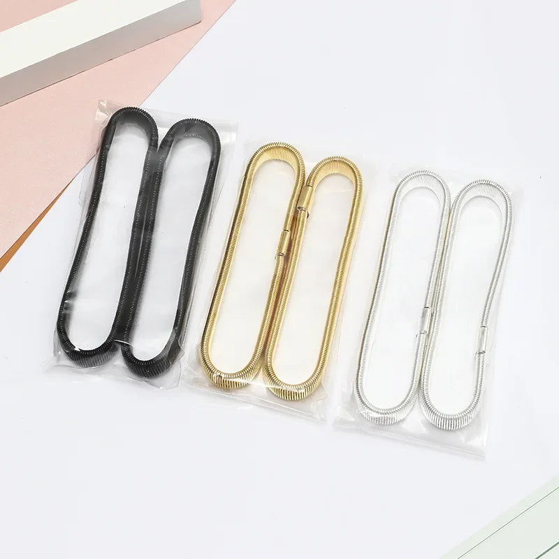 A collection of metal sleeve garters or adjustable arm bands in black, gold, and silver are displayed on a white background.