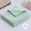 A stack of ten light mint green velvet cleaning face towels are displayed on a white surface.