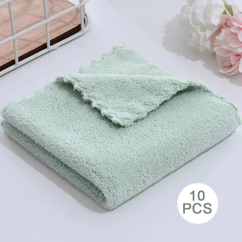 A stack of ten light mint green velvet cleaning face towels are displayed on a white surface.