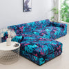 A vibrant teal and purple tropical leaf print sofa protector cover displayed on a white round stool.