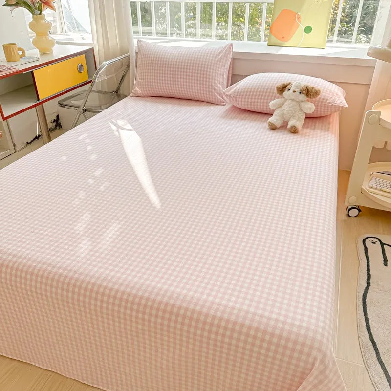 Pink gingham organic cotton bedding set with a white quilted flat sheet and pillow