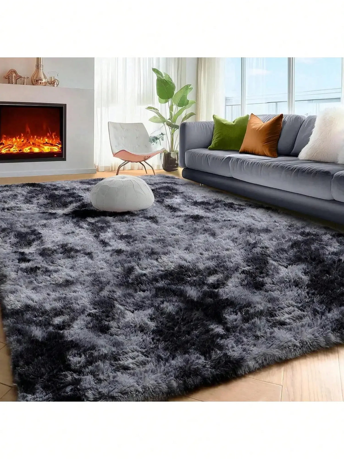 A dark gray plush long-pile area rug placed in a modern living room with a sofa and fireplace.