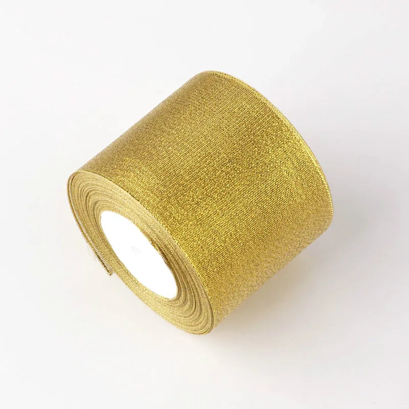 A roll of gold glitter organza ribbon used for gift wrapping and DIY crafts.