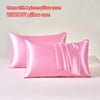 Two pink satin pillow cases without a pillow core displayed on a white surface.