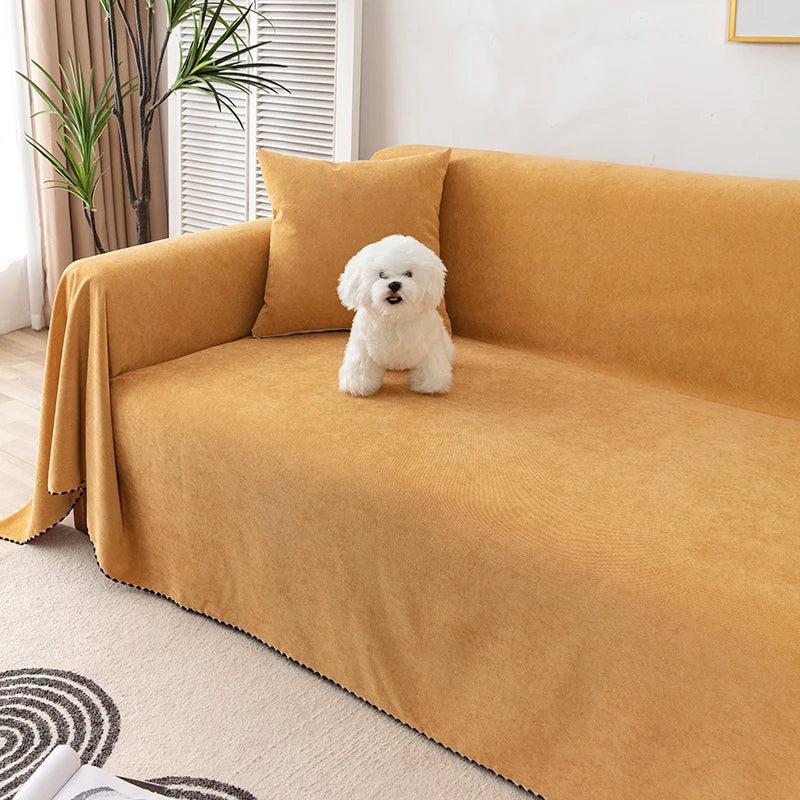 A fluffy white dog sits on a mustard yellow sofa covered with a matching fabric.