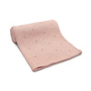 A light pink super soft cotton knit baby blanket folded and displayed on a white background.