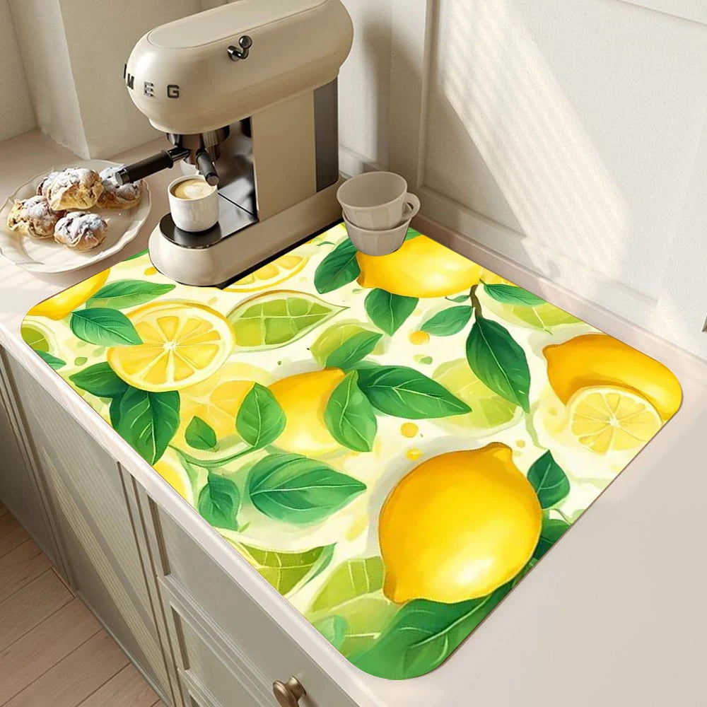 A yellow and green lemon printed non-slip dish drying mat placed on a kitchen counter next to a coffee grinder.
