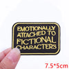 Black embroidered patch with yellow text that reads Emotionally Attached to Fictional Characters