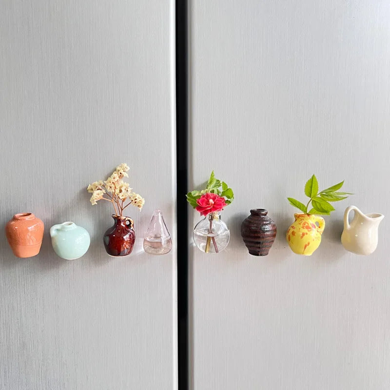 A collection of small ceramic landscape items in various colors and textures displayed on a refrigerator door.