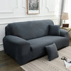 A charcoal gray elegant faux silk sofa cover placed on a light rug in a well-lit room.
