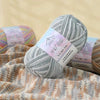 A ball of gray yarn is shown next to a knitted fabric featuring multicolored stripes.