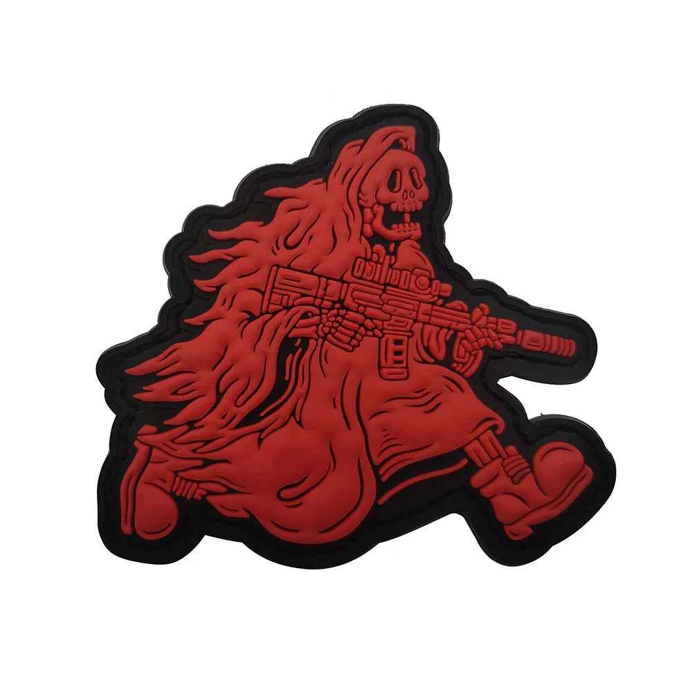 A red glow-in-the-dark skull and crossbones biker patch featuring a skeletal figure with flowing hair and a weapon.