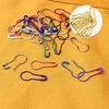 A collection of colorful safety bulb pins for knitting and sewing displayed on a yellow fabric background.