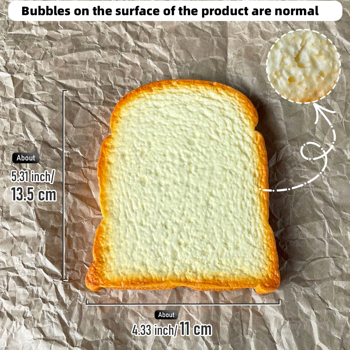 A slice of toast is shown on brown paper, with bubbles on the surface and a small white sphere nearby.
