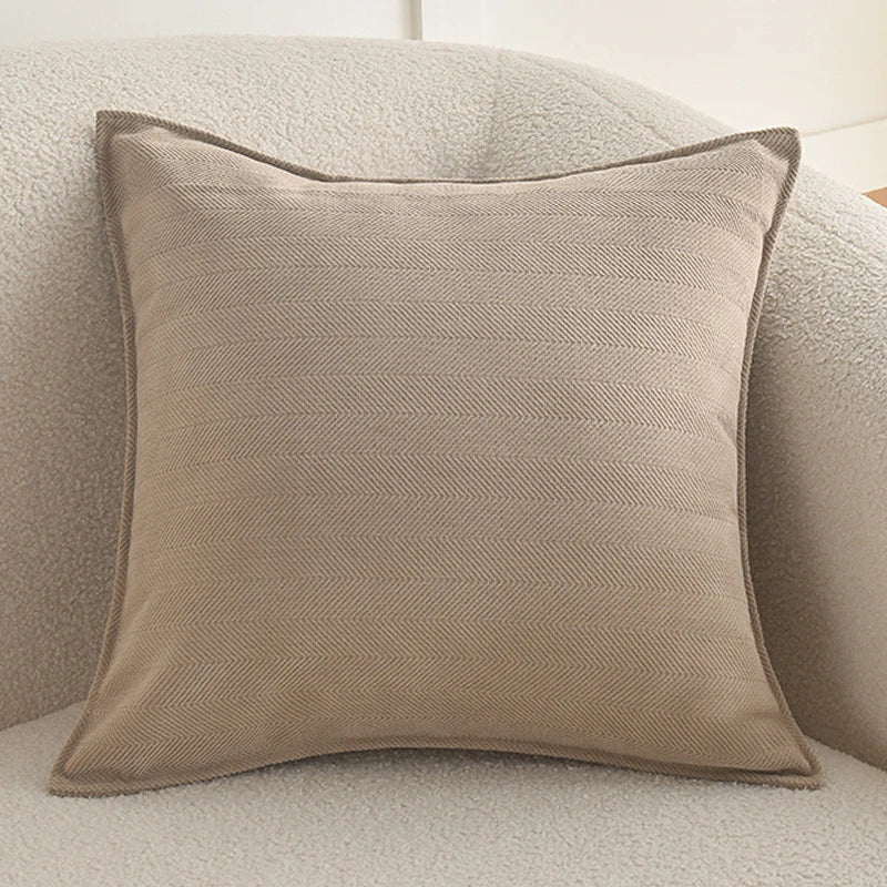 A beige luxury chenille throw pillow cover resting on a light-colored, textured sofa.