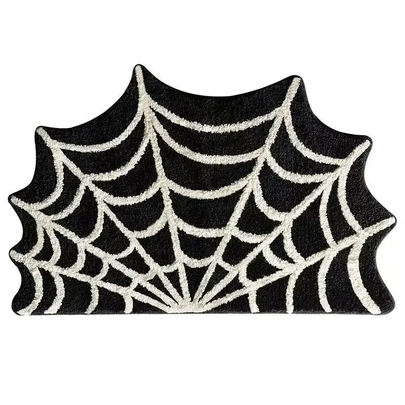 A black and white spider web design on a door mat for Halloween