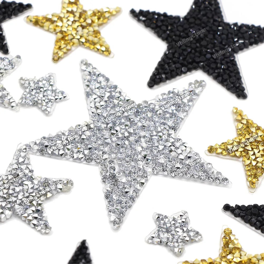 A collection of various glitter rhinestone star-shaped iron-on patches in gold, silver, and black.