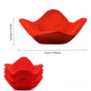 A bright red quilted microwave bowl cozy with a fluted design shown from the top and side.