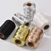 Rolls of glitter metallic yarn in silver, gold, and pink shades for crafting projects