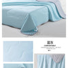 Light blue ice silk summer cooling blanket folded and displayed on a white surface.