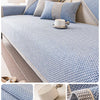 Close-up view of a blue woven sofa cushion cover with beige accents and a white cup on the fabric.