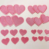 A collection of 24 pink iron-on love heart embroidered patches for DIY clothing.