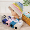 A display of medium-thick hand-woven cotton yarn in a rainbow pattern on a head and several spools.