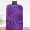Purple crochet ice rope in a spool with a green cap resting on a woven mat.